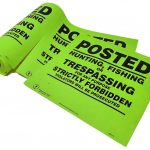 posted no trespassing sign on a roll lime green